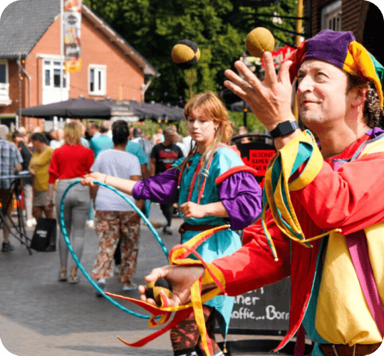 Jongleur in kleurrijk middeleeuws kostuum op het festijn