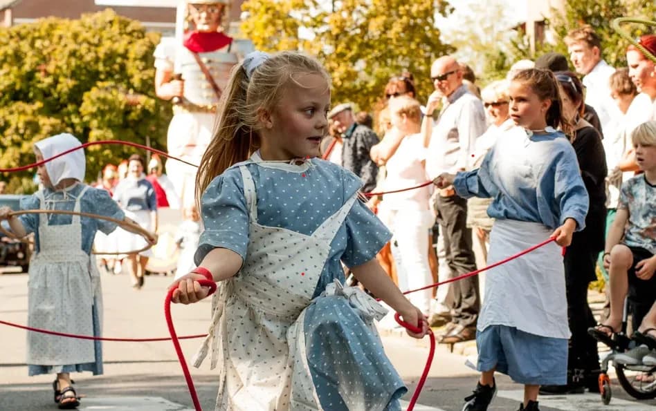 Dansende meisjes in Brueghelkostuum met springtouwen tijdens de Brueghelstoet Losser